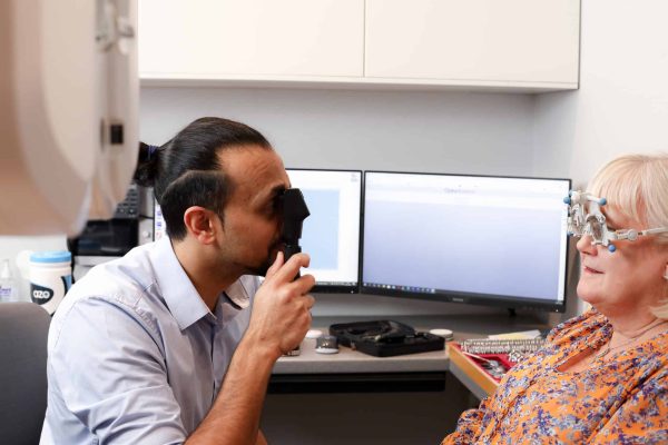 Optician giving patient and eye test as she read about how important it is to get an eye tests for drivers